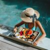 Girl relaxing and eating fruits in the pool on luxury villa in Bali. Exotic summer diet. Tropical beach lifestyle.