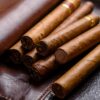 Brown cigars nestled in dark leather